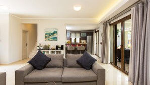 Ein modernes Wohnzimmer mit einer Couch, einem Couchtisch und einer Küche im Hintergrund.