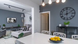 Ein modernes Wohnzimmer mit einer Couch, einem Couchtisch und einem Essbereich mit Tisch und Stühlen.