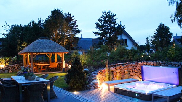Un espace extérieur aménagé avec un patio, un jacuzzi, une terrasse en bois et un gazebo.