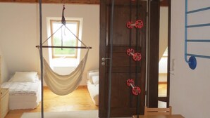 A room with a hammock, a wooden table, a bed, and a door. - Cozy Swedish house with fireplace, sauna, winter gardens, WLAN New!!! (Biendorf)