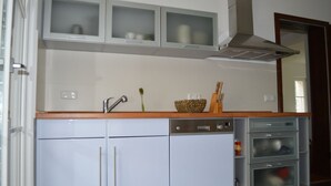 A compact kitchen with white cabinets, a built-in oven, and a microwave. - Cozy Swedish house with fireplace, sauna, winter gardens, WLAN New!!! (Biendorf)