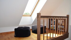 A room with a sloped ceiling, wooden floor, and a wooden chair. - Cozy Swedish house with fireplace, sauna, winter gardens, WLAN New!!! (Biendorf)