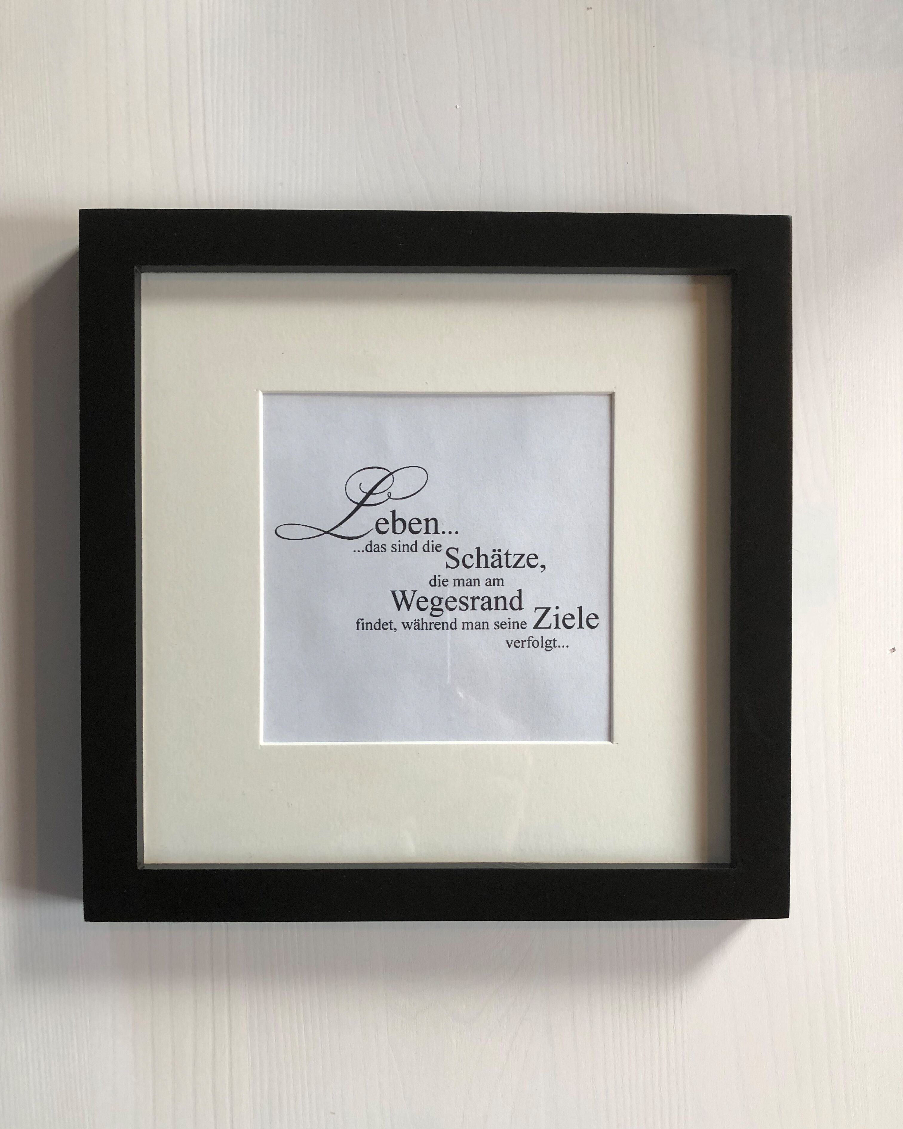 Ein gerahmtes Zitat an einer Wand.