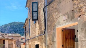 A narrow street with stone buildings, a wooden door, and a number 7 sign. - Centrally located in Pollensa with wonderful roof terrace views (Pollença)