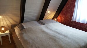 Ein Schlafzimmer mit einem Bett, zwei Nachttischen und einer Lampe.