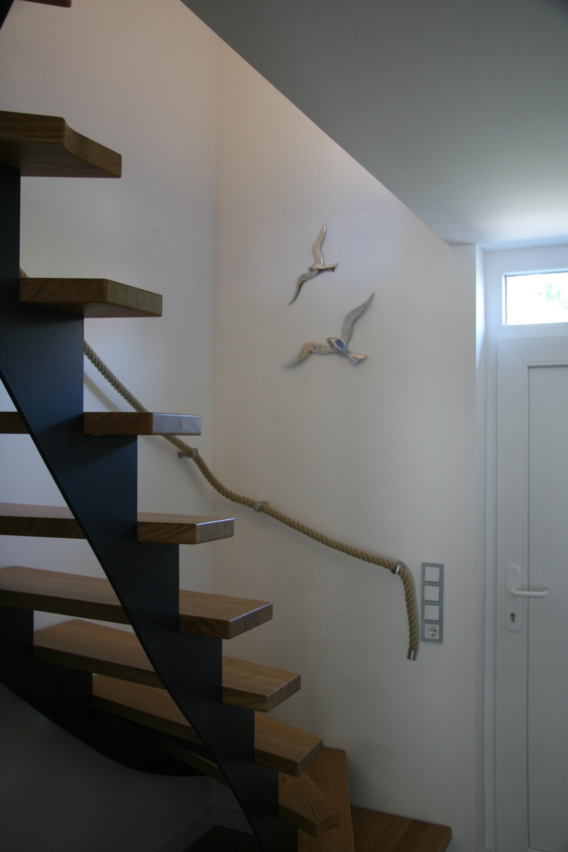 Eine Treppe mit Holzstufen und einem Seilgeländer.