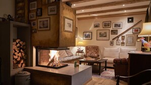 A cozy living room with a fireplace, a sofa, a chair, and a coffee table. - Welcome to Paradise (Bled)