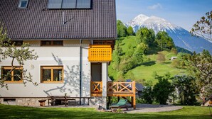A house with a sloped roof, solar panels, and a wooden deck with a table and chairs. - Welcome to Paradise (Bled)
