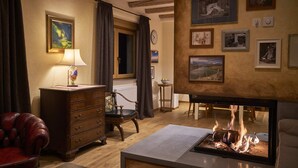A cozy living room with a fireplace, wooden furniture, and framed artwork on the walls. - Welcome to Paradise (Bled)