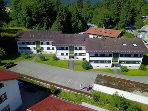 A multi-story building with a parking lot and a small garden area. - Apartment on the Zugspitze (Grainau)