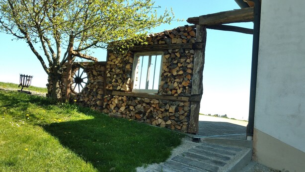 A rustic stone wall with a wooden door and a window, a wooden bench, and a tree in the background. - Vacation on the farm in beautiful Koesslarn in Lower Bavaria (Kößlarn)