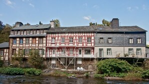 Ein traditionelles Fachwerkhäuschen mit einem Fluss davor.