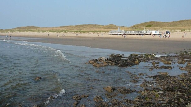 Una playa con un muelle y un bote.