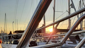 A marina with boats docked, a clear sky, and a sunset in the background. - Penthouse vacation apartment "Auszeit" 100 m from the center. Beach, preferably with dog, WLan incl. (Laboe)
