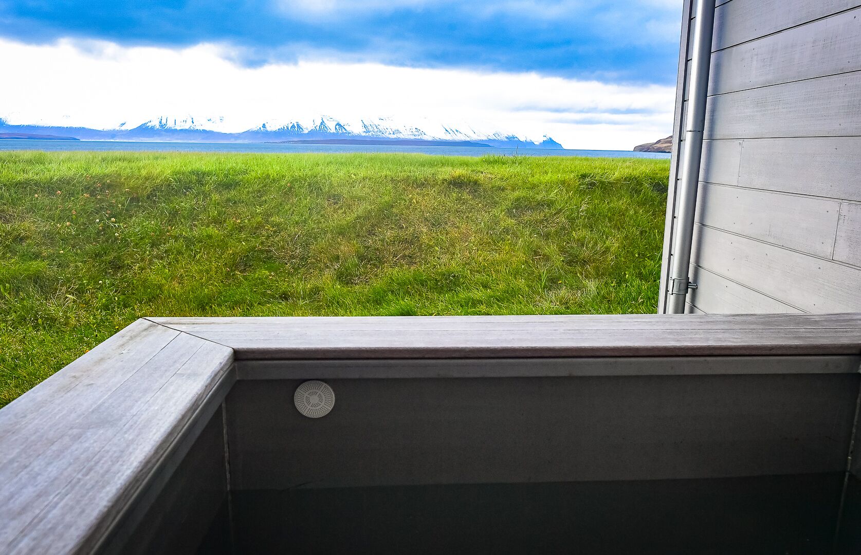 Ein Balkon mit Blick auf ein grünes Feld und ferne Berge.