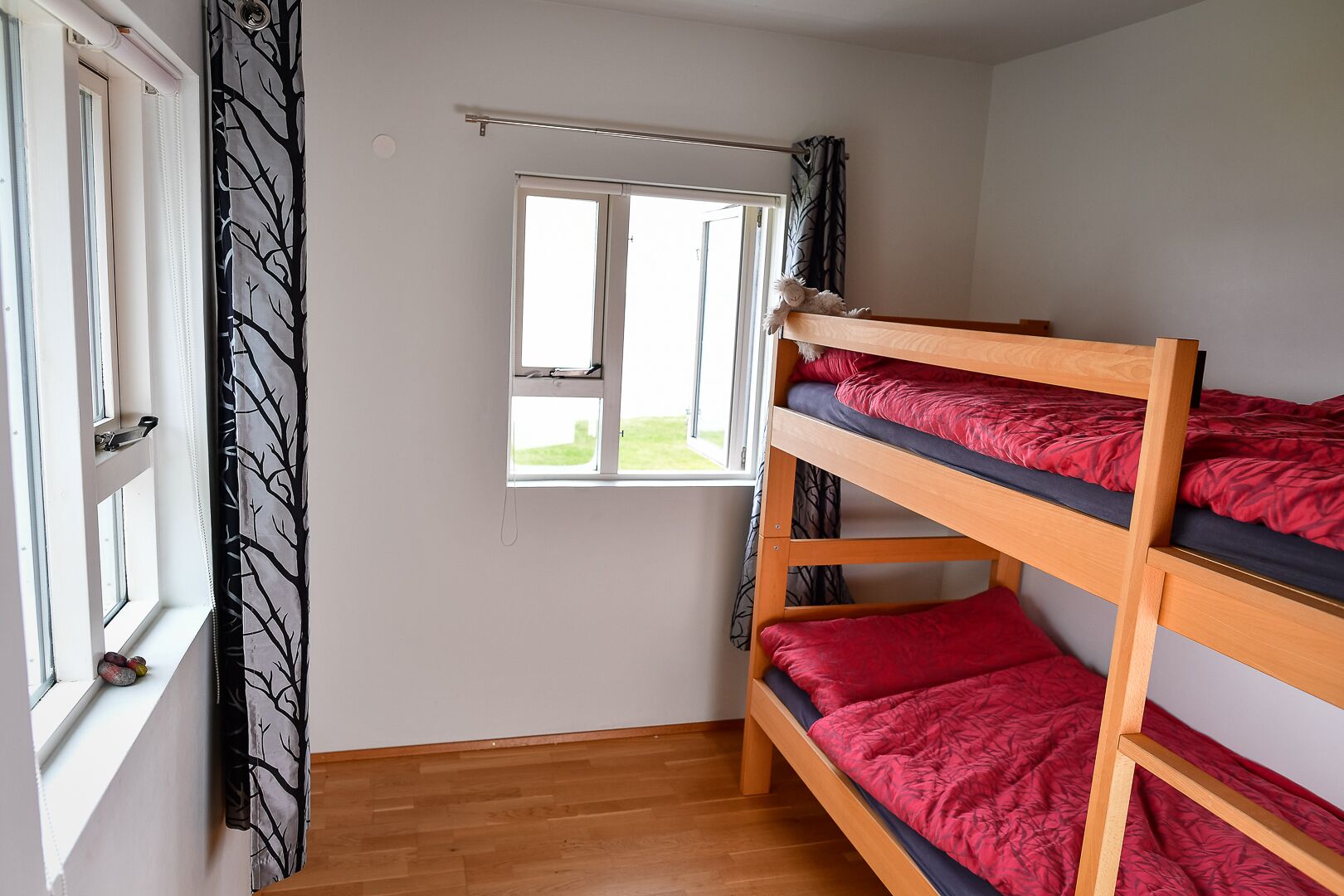 A bunk bed room with a window and a curtain.