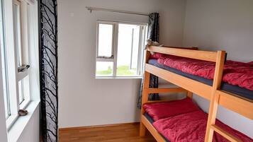 A bunk bed room with a window and a curtain.