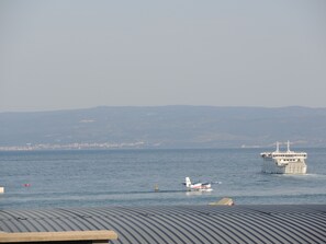 A ferry boat with a flat deck and a cabin structure, traveling on calm waters. - ****Apartment Xenios with sea view, promenade, old town, balcony (Split)