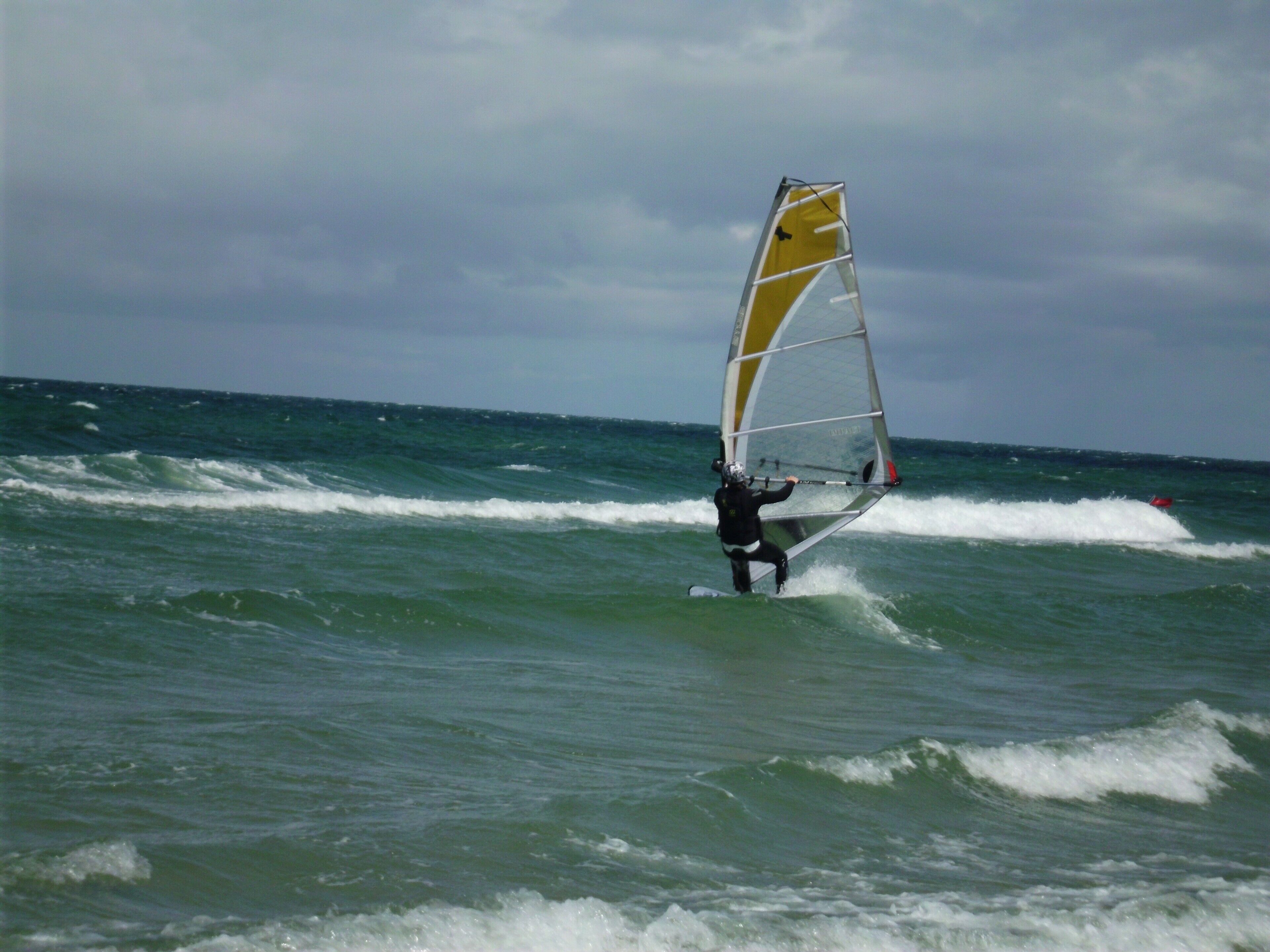 Eine Person surft auf dem Meer.