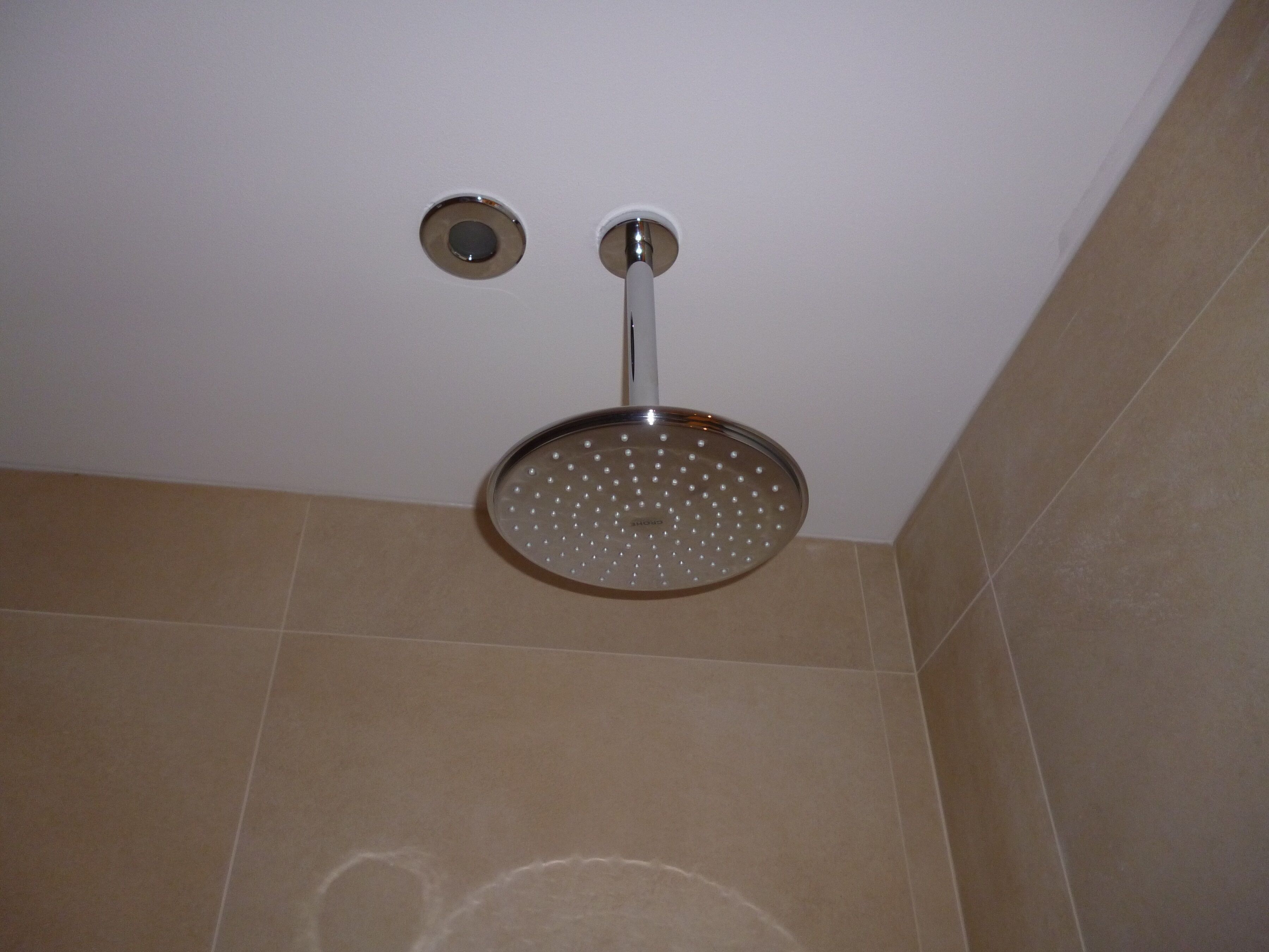 Un cabezal de ducha con diseño circular y una perilla de control.