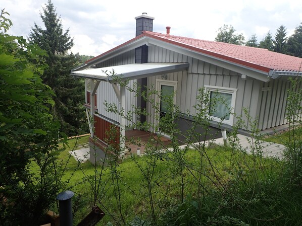 A two-story house with a red roof, a covered porch, and a well-maintained garden. - High quality holiday home with WiFi, fireplace & underfloor heating (Harzgerode)
