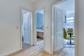 A hallway with two open doors leading to a bedroom and a dining area. - Schmidt-each other apartment 9 (Norderney)