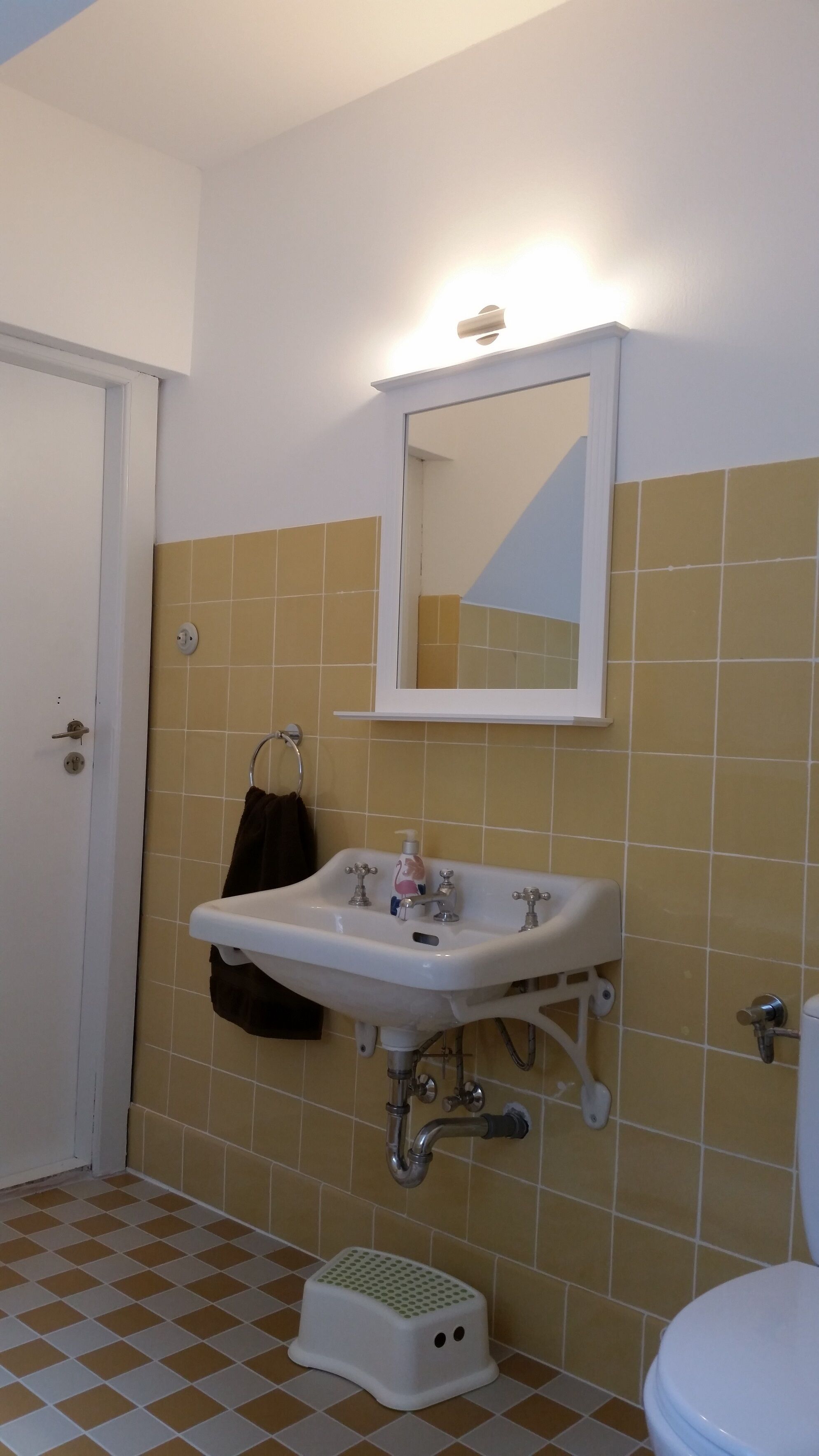 Ein Badezimmer mit Waschbecken, Spiegel und Toilette.