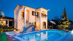 A two-story house with a swimming pool, outdoor furniture, and a staircase leading to the upper floor. - A luxurious house in a quiet village near the sea (Labin)