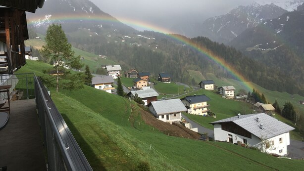 A view of a mountain village with houses and a rainbow. - Vacation apartment**** with sauna, herbal steam bath, solarium and fitness room (Fontanella)