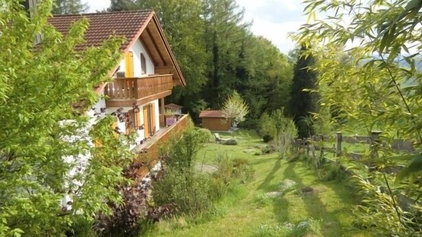 A two-story house with a balcony, surrounded by lush greenery and trees. - Vacation home in a fantastic location in Upper Bavaria (Oberhausen)