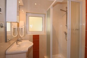 Een douche, een haardroger, handdoeken, shampoo