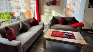 Ein modernes Wohnzimmer mit zwei Sofas, einem Couchtisch und einem Gemälde einer roten Rose an der Wand.