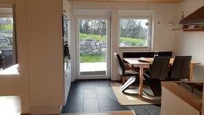 Una cocina moderna con comedor, ventanas amplias y vistas al exterior.