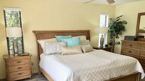 A bedroom with a wooden bed, multiple pillows, a nightstand with a lamp, a dresser, and a potted plant. - VILLA BELLY :-) heated pool. free WIFI, very private, Garage, BBQ, Kings Lake (Naples)