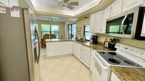 A kitchen with white cabinets, a granite countertop, a built-in oven, and a microwave. - VILLA BELLY :-) heated pool. free WIFI, very private, Garage, BBQ, Kings Lake (Naples)