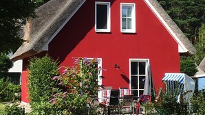 A red house with a steeply pitched roof and a chimney. - Enjoy the autumn under the thatched roof - close to the beach, comfortable, Wi-Fi, sauna, dog willk. (Glowe)