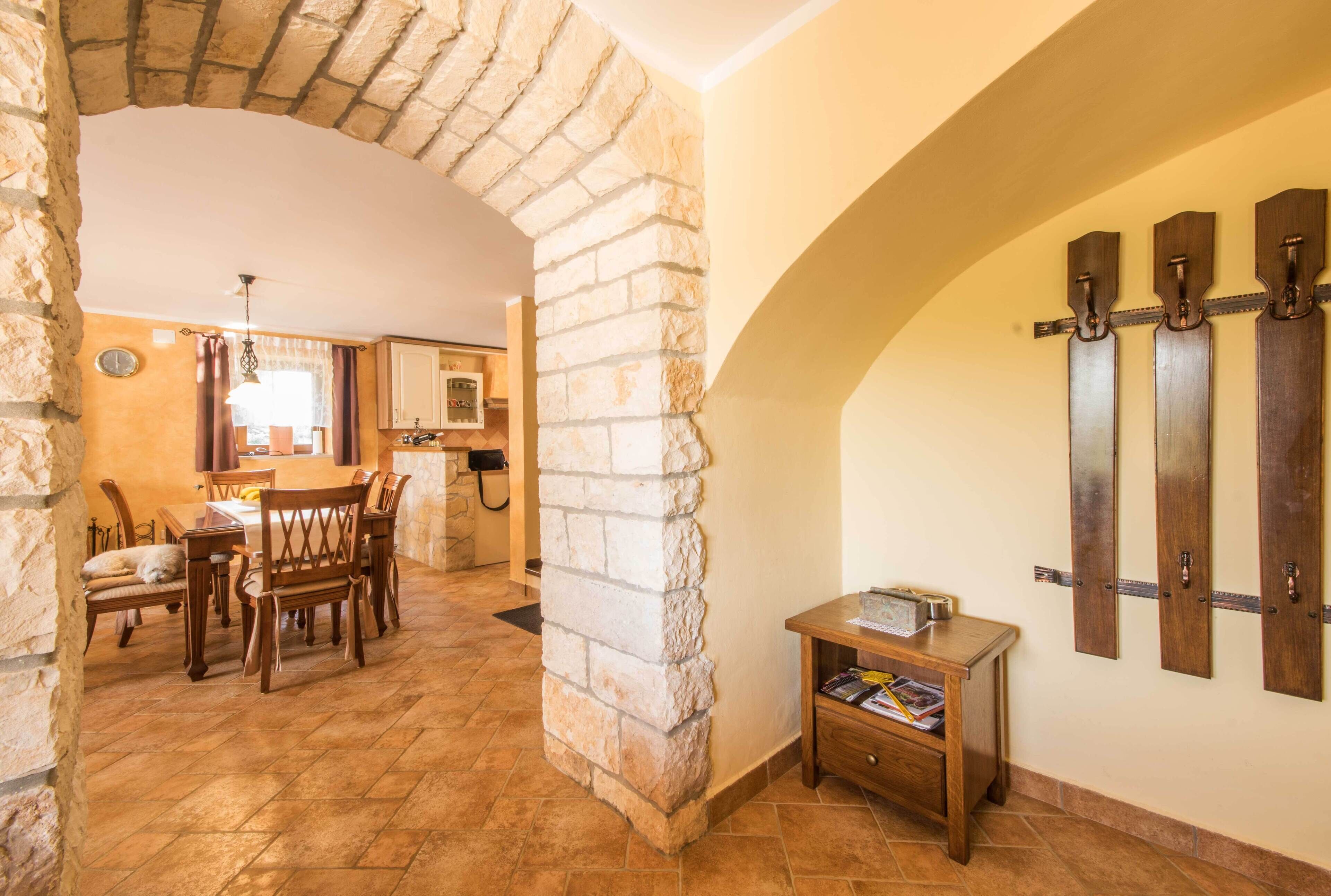 A dining area with stone walls, wooden furniture, and a small table with magazines.