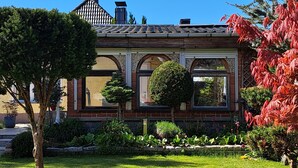A traditional building with a symmetrical facade, arched windows, and a tiled roof.