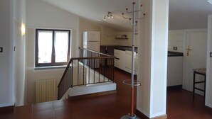 Un appartement moderne doté d’un escalier, d’une cuisine et d’un coin repas.