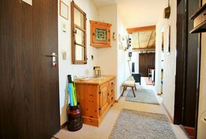 A hallway with a wooden cabinet, a small table, and a rug. - Vacation apartment w/south-west balcony, fireplace, pool & an underground garage (Davos)