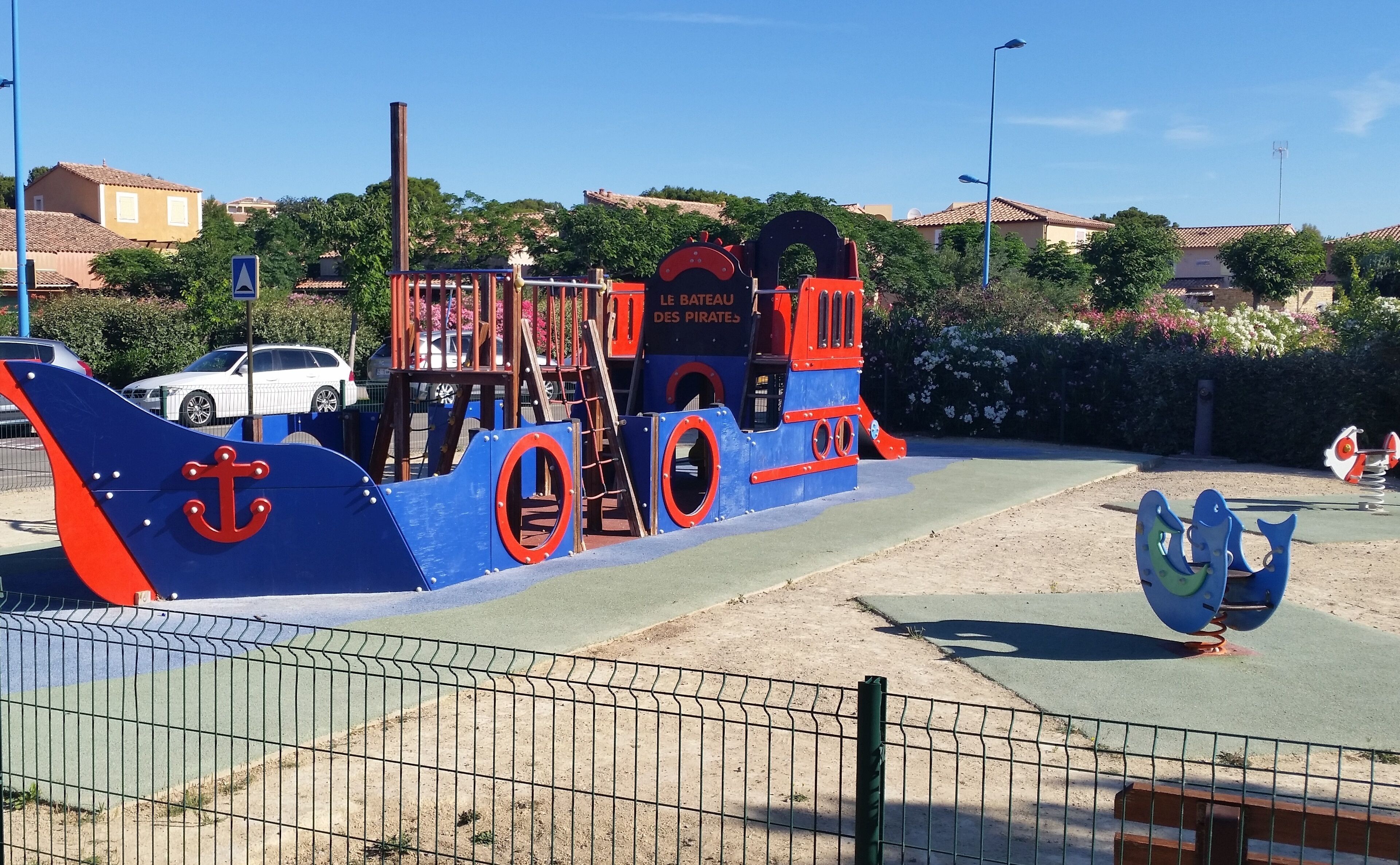 A playground with a pirate ship theme, including a ship's wheel and anchor.