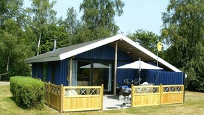 A single-story building with a dark blue exterior, a sloped roof, and a covered patio area.