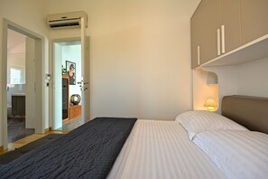 Een slaapkamer met een bed, een bedlampje en een kledingkast.