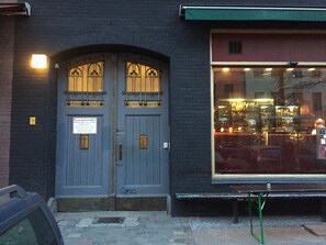 A building with a dark facade, a large window with a reflection of lights, and a sign on the door. - rainbow loft 9 in the heart of Kreuzberg (Bezirk Friedrichshain-Kreuzberg)