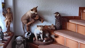A staircase with multiple levels, each adorned with a variety of animal figurines and a macrame wall hanging. - Beautiful, large, comfortable vacation apartment to feel at home in. (Dachsberg (Südschwarzwald))