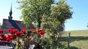 A garden with a bench and a table, surrounded by various plants and flowers. - Beautiful, large, comfortable vacation apartment to feel at home in. (Dachsberg (Südschwarzwald))
