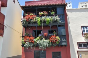 Un edificio con varios balcones decorados con plantas y flores en macetas.
