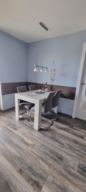 Comedor con mesa, sillas y lámpara colgante.