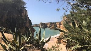 A coastal landscape with cliffs, a sandy beach, and cacti. - Detached villa with sea view, heated pool and air conditioning (Caramujeira)