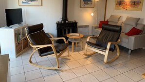 A cozy living room with a fireplace, rocking chairs, a sofa, and a television. - Directly behind the dunes in the Fabiola Beach Park (Wenduine)
